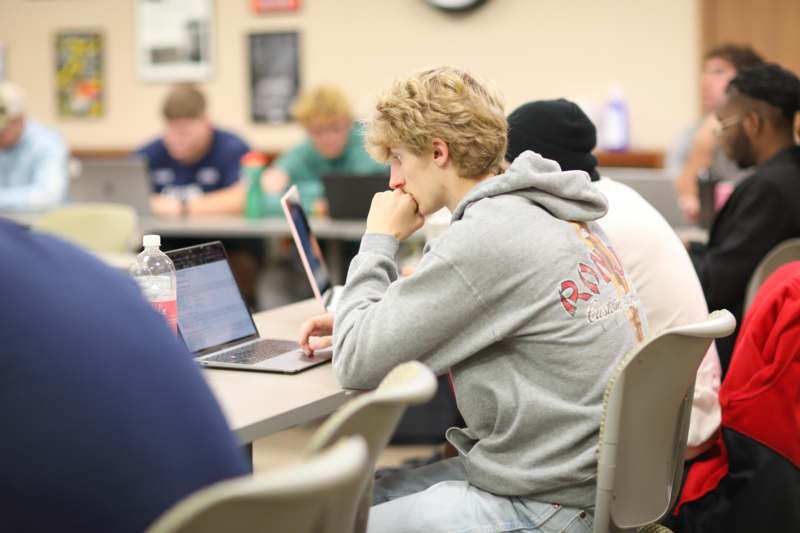 a man sitting at a table with a laptop
