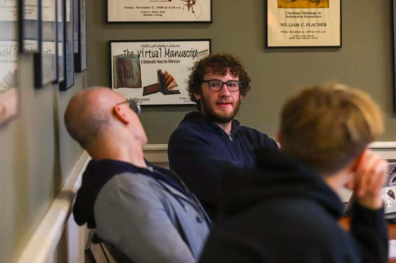 a man sitting in a room with other people