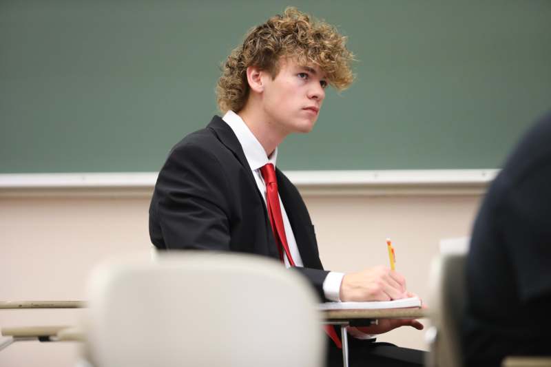 a man in a suit and tie sitting at a desk