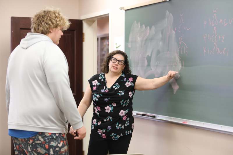 a woman pointing at a chalkboard