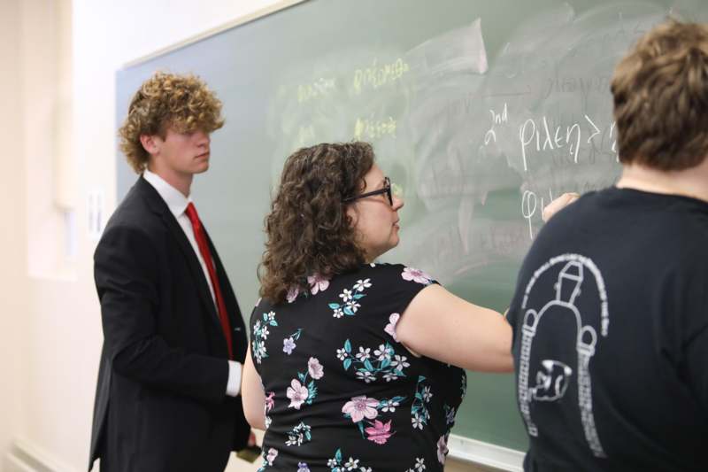 a group of people writing on a chalkboard