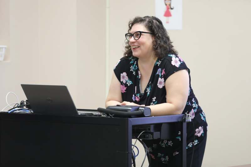 a woman smiling at a computer