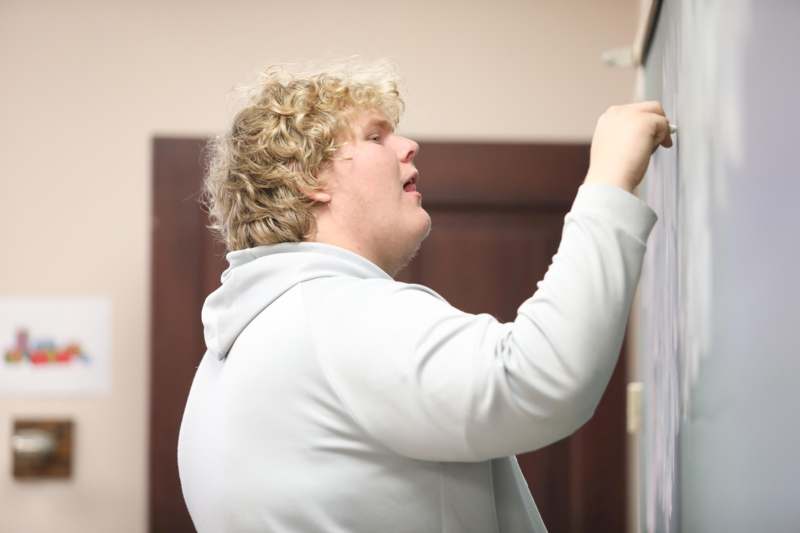 a man writing on a blackboard