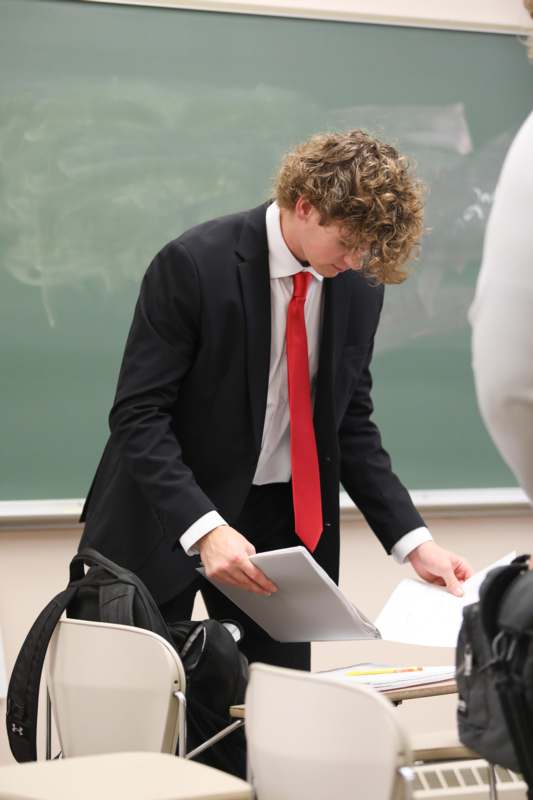 a man in a suit and tie holding a paper