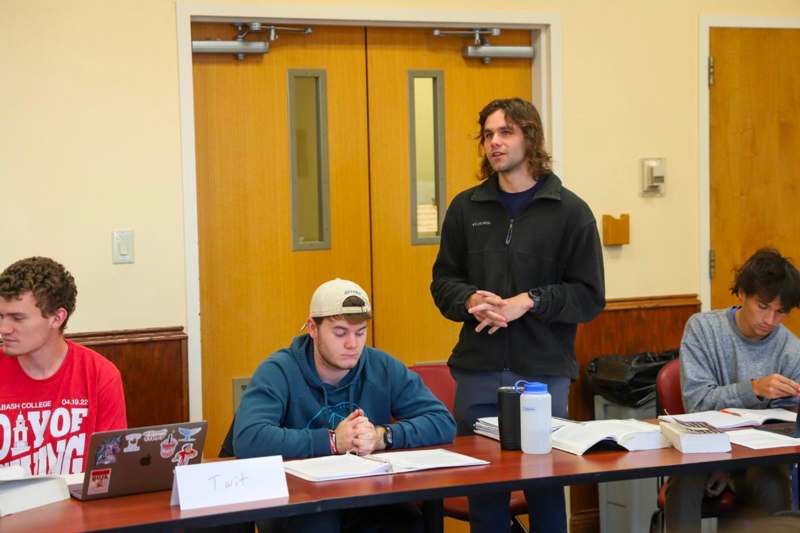 a man standing next to a man standing in front of a table