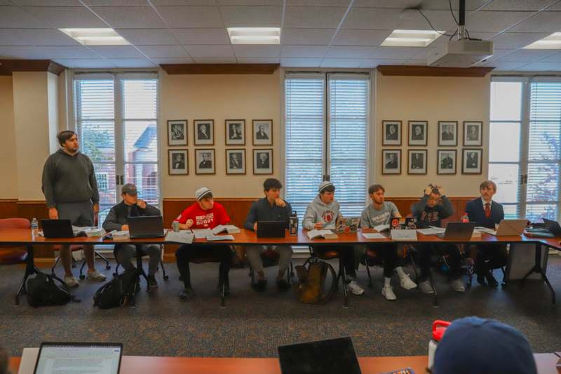 a group of people sitting at a long table