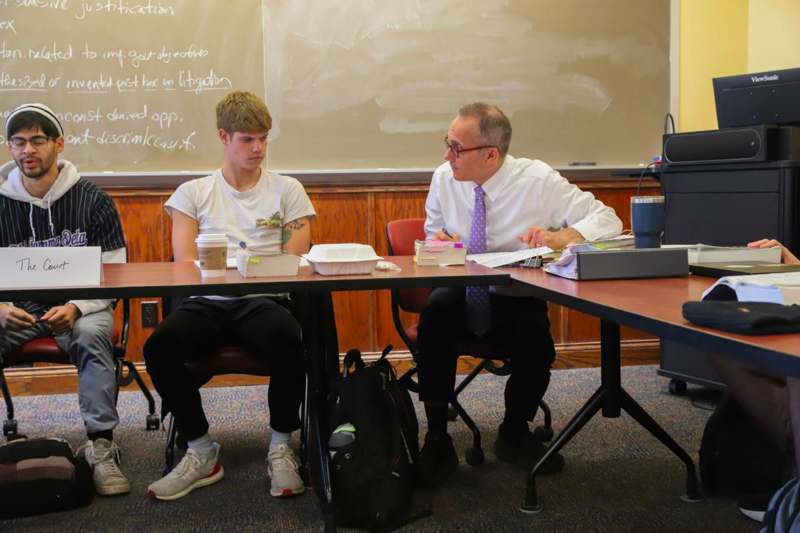 a man sitting at a table with a man in a tie