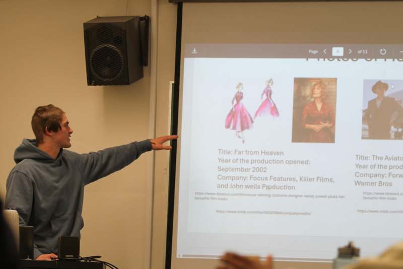 a man pointing at a projector screen