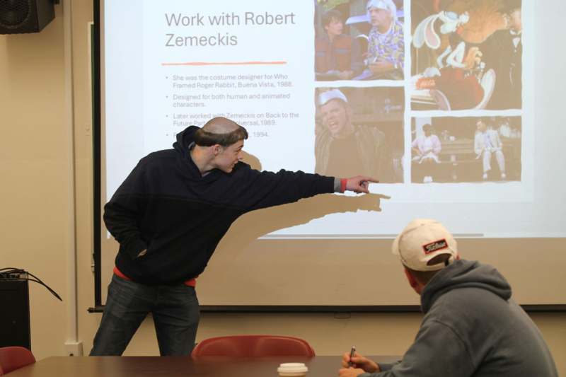 a man pointing at a projector screen