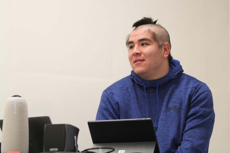 a man with shaved head sitting at a table