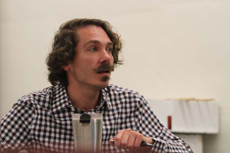 a man with a mustache sitting at a table