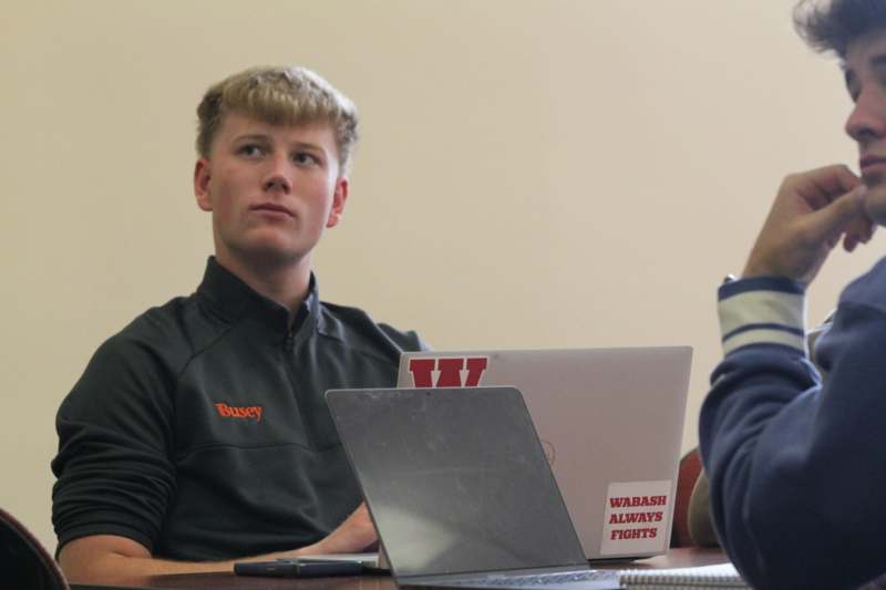 a man sitting at a table with a laptop