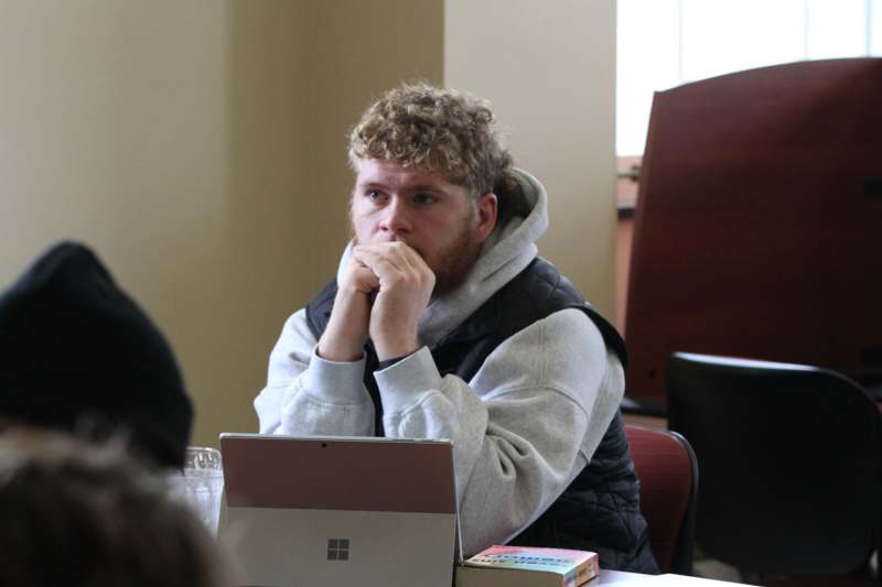a man sitting at a table with his hands on his chin
