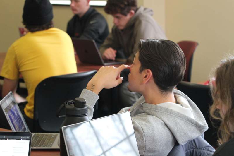 a person sitting at a table with a laptop