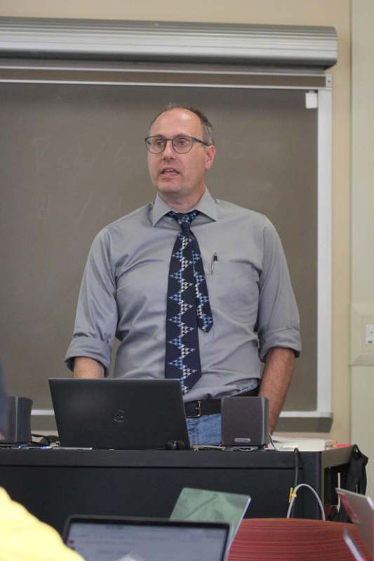 a man standing in front of a laptop