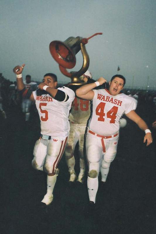 a football players holding a trophy