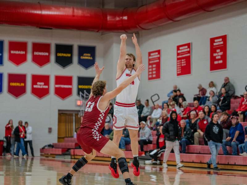 a basketball player in a red uniform jumping to reach the ball