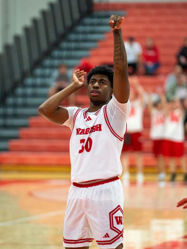 a basketball player in a white uniform with his arms up