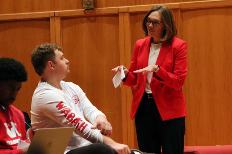 a woman in a red jacket talking to a man