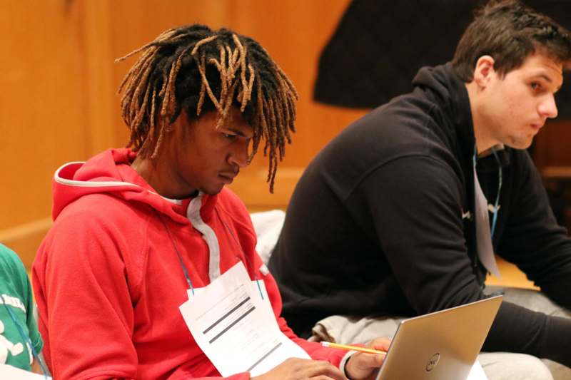 a man with dreadlocks looking at a laptop