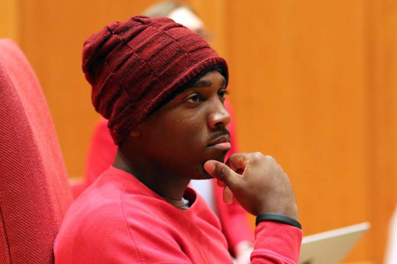 a man in a red shirt and a knit hat