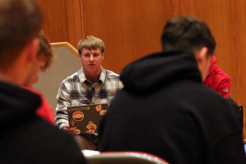 a man holding a box with a group of people in the background
