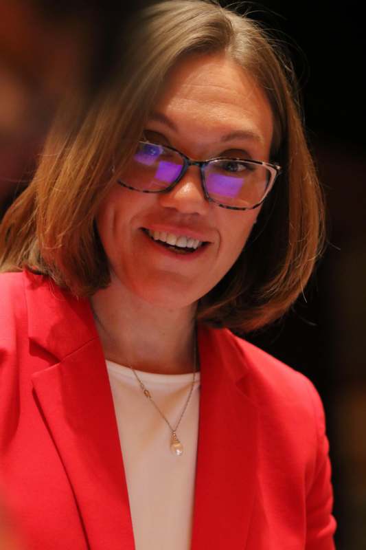 a woman wearing glasses and a red jacket