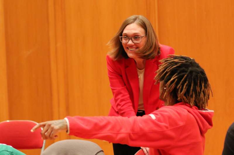 a woman in red jacket pointing at another woman