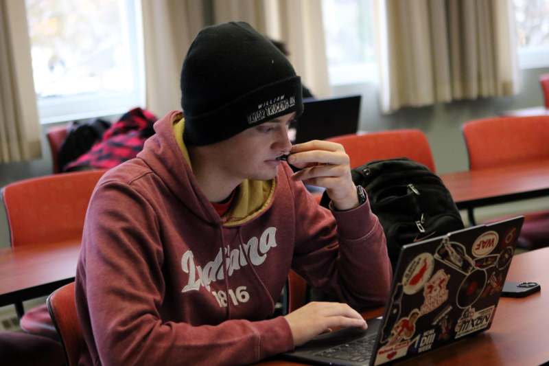 a man in a beanie using a laptop
