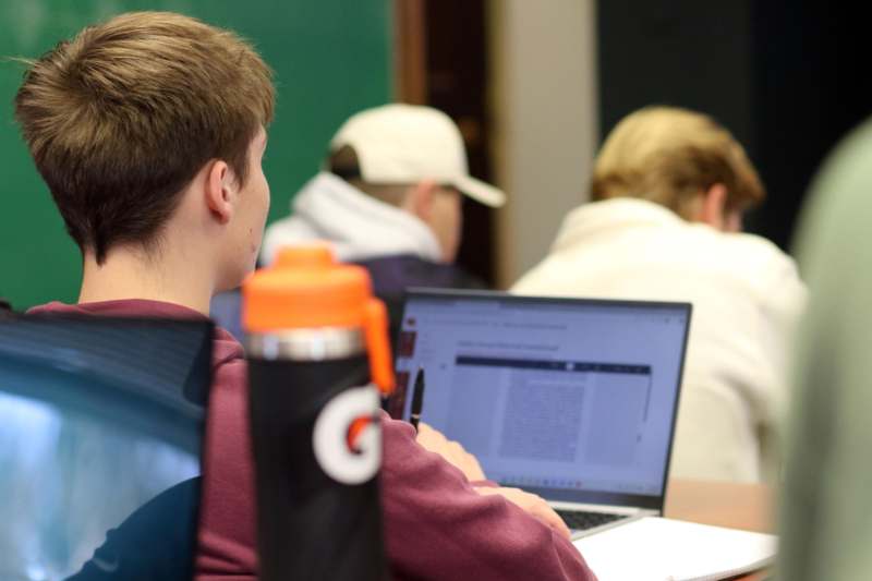 a man sitting at a desk with a laptop