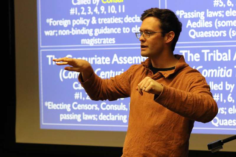 a man standing in front of a large screen