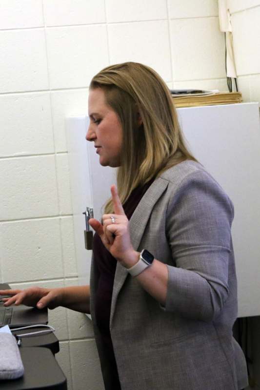 a woman in a suit holding up her hand