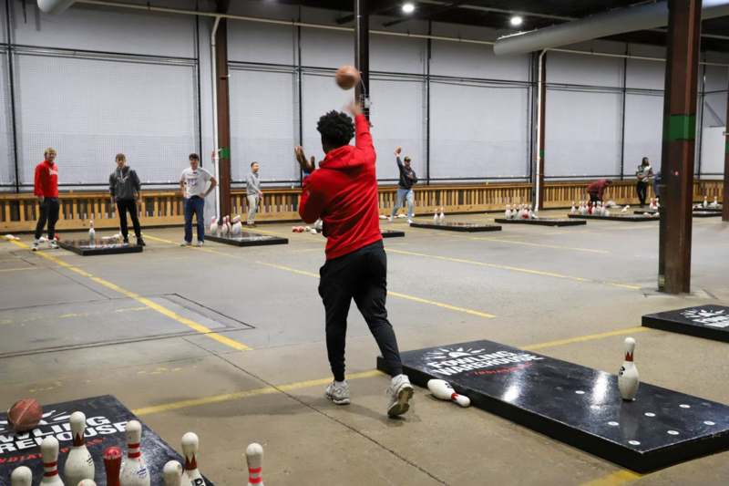 a man throwing a ball in a bowling alley