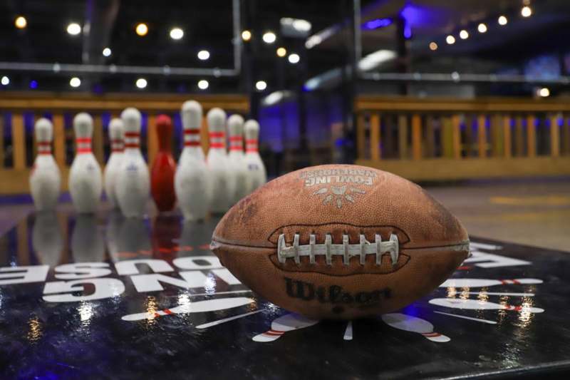 a football on a table with bowling pins in the background