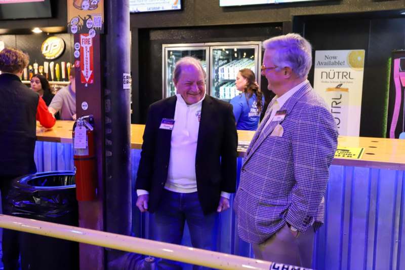 two men standing in a bar