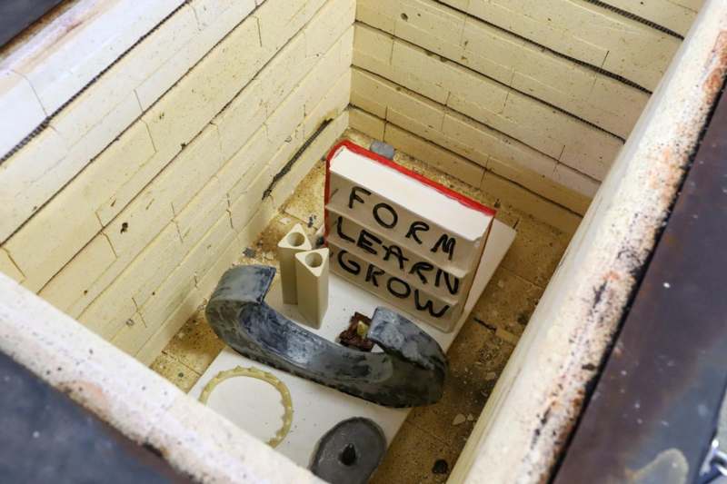a toilet with a sign and a couple of objects