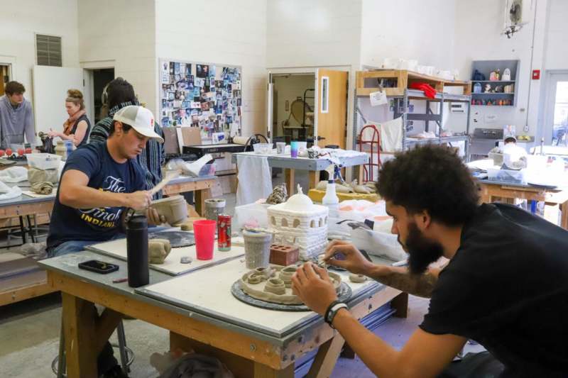 a group of men working on a clay sculpture
