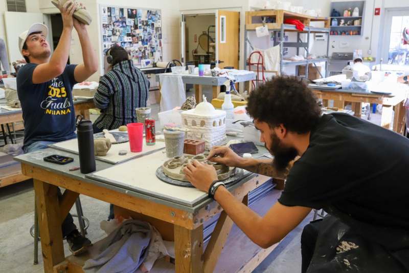 a group of people working on a pottery