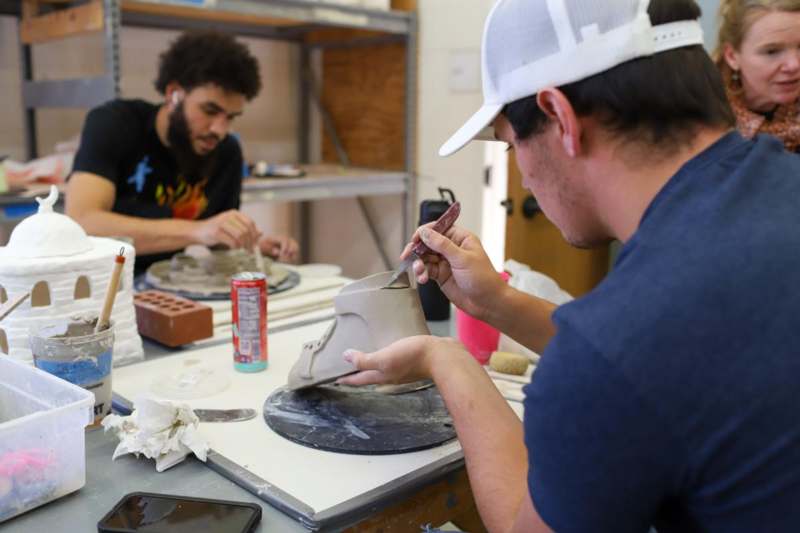 a man painting a clay sculpture