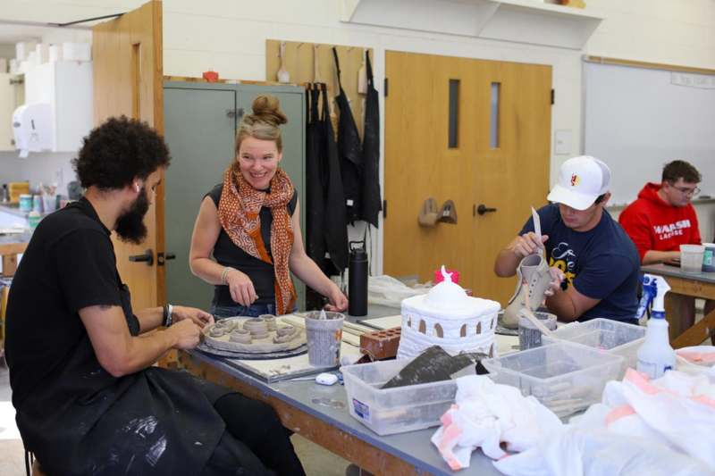a group of people working on a pottery project