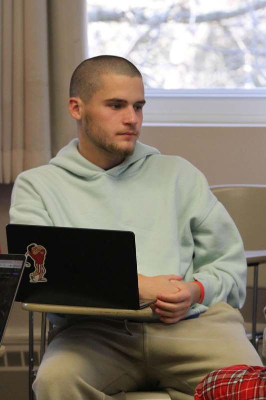 a man sitting in a chair with a laptop