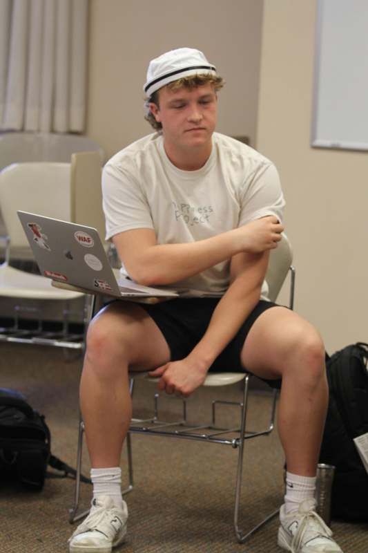 a man sitting in a chair with a laptop