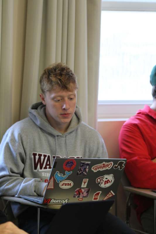 a man sitting at a desk with a laptop