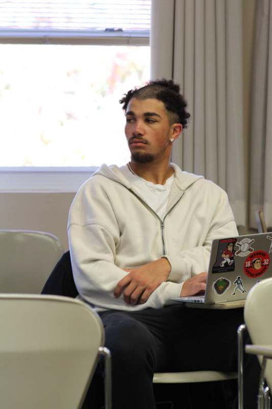 a man sitting in a chair with a laptop