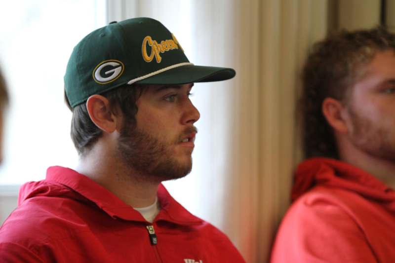 a man in a red jacket and green hat