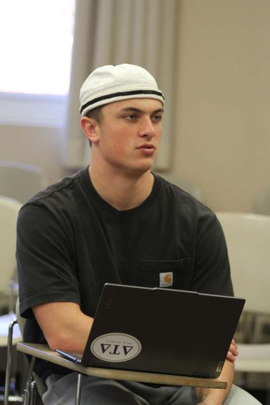 a man wearing a white hat and black shirt