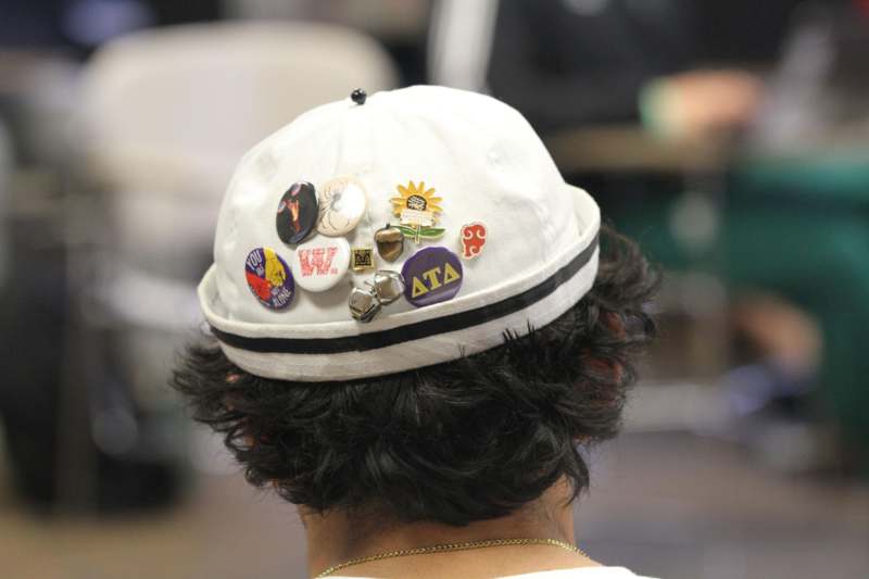 a person wearing a hat with pins on their head