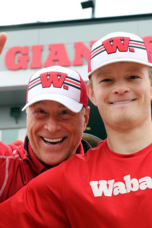 two men wearing red shirts and hats