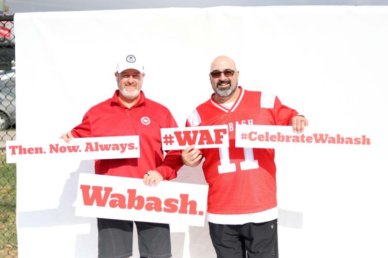 two men holding signs posing for the camera