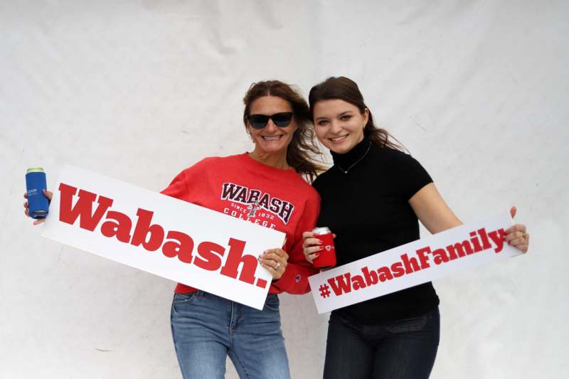 two women holding signs and smiling